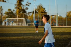A teenager plays soccer outdoors on a sunny day, enjoying friendly competition. — La Grada Online: Get the Latest Sports News