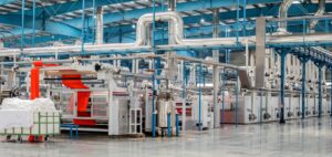 Interior view of a modern fabric manufacturing facility with machinery and equipment