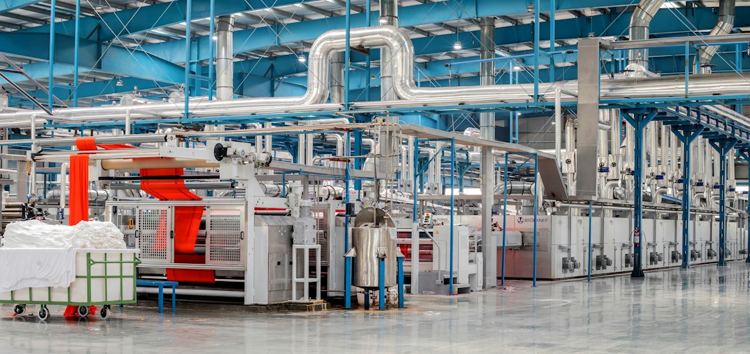 Interior view of a modern fabric manufacturing facility with machinery and equipment